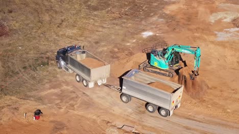 Eimer-Mit-Erde-Von-Einem-Bagger-In-Einen-LKW-Und-Einen-Anhänger-Laden