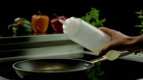 Slow-motion-tracking-shot-with-sliding-bottle-of-oil-and-pouring-it-in-a-saucepan