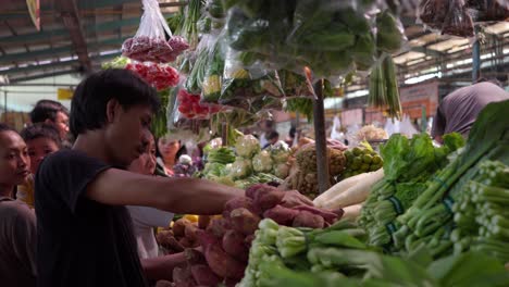 Männlicher-Verkäufer-Am-Gemüsestand-Auf-Einem-Lokalen-Markt-In-Indonesien,-Südostasien