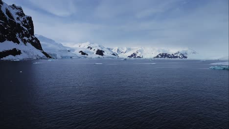 Global-Warming-and-Climate-Change-with-Melting-Ice-and-Warming-Ocean-in-Antarctica,-Mountains-and-Winter-Scenery-on-Antarctic-Peninsula-in-Beautiful-Dramatic-Coastal-Scene