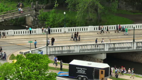 Gente-Caminando-Sobre-El-Puente-Que-Cruza-Sager-Creek-Durante-El-50º-Festival-Dogwood-En-Siloam-Springs,-Arkansas.