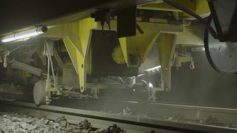 Close-up-view-of-train-machinery-at-work-on-tracks-during-nighttime