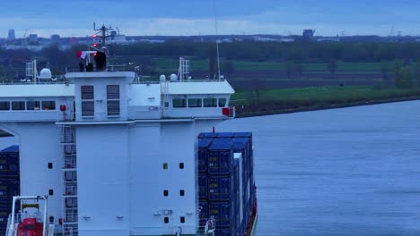 BG-Green-Container-Ship-With-Load-Navigating-Across-River-In-Barendrecht,-Netherlands