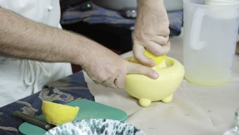 chef-squeeze-yellow-lemon-with-squeezer-preparing-juice