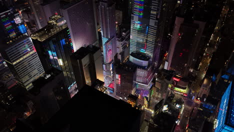 Aerial-view-circling-the-night-lit-Times-square-intersection,-in-Manhattan,-NYC