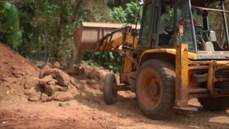 JCB-bulldozer-engaged-in-dumping-clay-after-digging-a-trench,-Close-up-shot