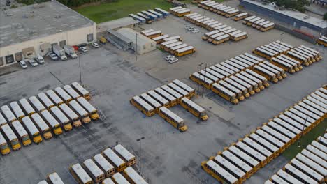 Vista-Por-Drones-De-Una-Fila-De-Autobuses-Escolares-Amarillos-En-Un-Gran-Estacionamiento