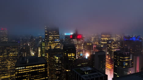 Drone-Orbitando-El-Rascacielos-4-Times-Square,-Noche-Con-Nubes-Bajas-En-Nueva-York