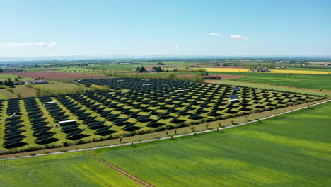 A-large-solar-farm-in-a-rural-area-on-a-sunny-day,-aerial-view