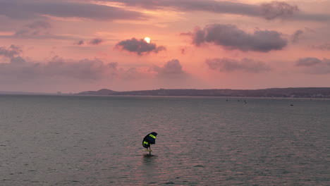 Drohne-Steigt-über-Isoliertem-Flügelfoiler-Auf-Und-Reitet-Lange-über-Dem-Offenen-Meer-Bei-Sonnenuntergang