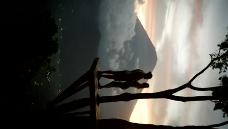 Mount-Agung,-tree-platform-misty-sunset,-affectionate-people,-vertical