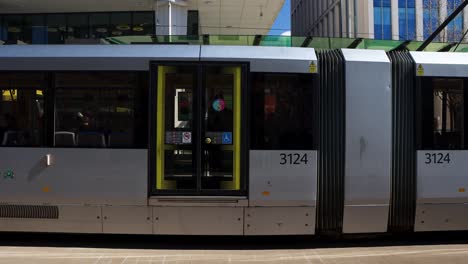 Manchester-city-Metrolink-tram-stopped-at-station-downtown,-static-view