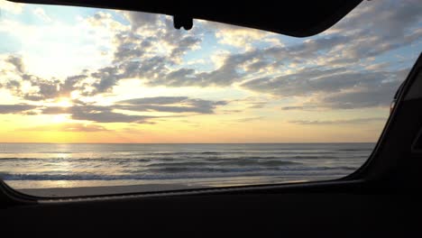 Slider-shot-of-the-sunset-and-sea-view-from-a-car's-trunk