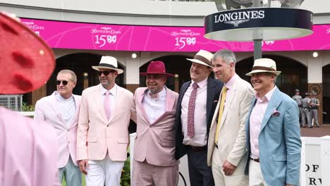 Footage-of-a-group-of-men-posing-together-for-a-photo-in-the-paddock-at-Churchill-Downs-on-the-day-of-the-150th-Kentucky-Derby,-capturing-the-festive-atmosphere