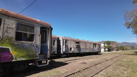 Train-Wagons-At-An-Abandoned-Train-Station-In-Peloponnese,-Greece---Panning-Shot