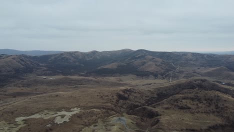 Luftperspektive-Der-Vulkanlandschaft-Der-Berge-Rumäniens-Mit-Ihren-Schlammvulkanen,-Trockenem-Land-Mit-Rissen,-Mit-Einigen-Isolierten-Häusern-Und-Dörfern