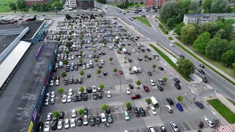 Un-Estacionamiento-Concurrido-Junto-A-Un-Gran-Centro-Comercial-En-Un-Día-Despejado,-Vista-Aérea