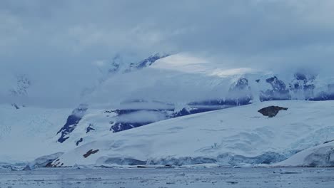 Paisaje-Costero-De-Las-Montañas-Invernales-De-La-Antártida,-Paisaje-Azul-Frío-Con-Capa-De-Hielo-Glaciar-Y-Agua-De-Mar-En-La-Costa,-Paisaje-Marino-De-La-Península-Antártica-En-Una-Dramática-Escena-Atmosférica-Azul-Cambiante