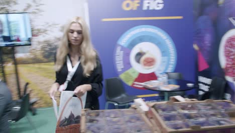 Empleada-De-Fig-Company,-Entregando-Mercancías-De-Marca-En-La-Feria-De-Alimentos,-España