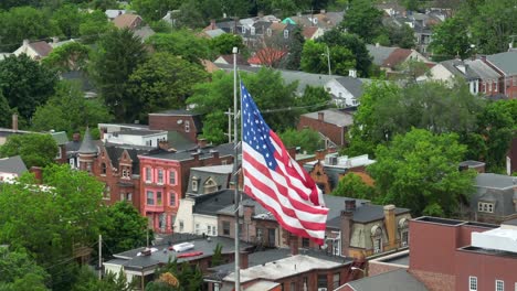 Patriotic-American-flag-waves-over-small-town-in-USA