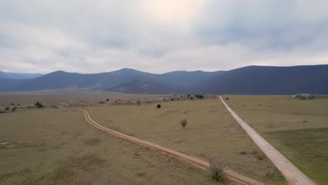 A-beautiful-landscape-drone-video-of-an-empty-field-with-a-road-in-Croatia-region-Lika-in-Europe