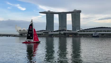 Sailing-boat-sailing-against-the-view-of-the-iconic-architecture-of-Marina-Bay-Sands-and-Art-Science-Museum-in-Singapore