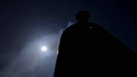 Silhouette-of-Chimney-Against-Full-Moon-Night-Sky-with-Smokes