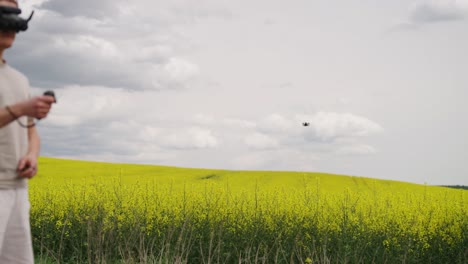 El-Piloto-De-Drones-FPV-Utiliza-El-Control-Remoto-De-Movimiento-Rc-Para-Acelerar-El-Avión-Sobre-El-Campo-De-Colza