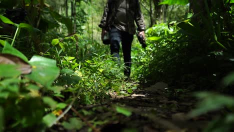 Asian-photographer-man-walks-through-tropical-rainforest