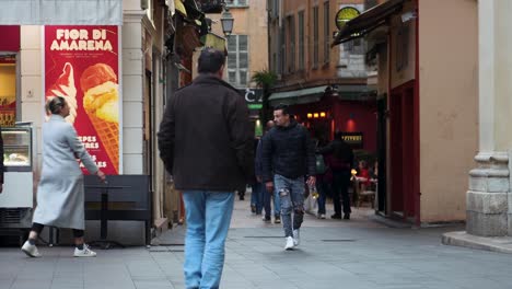 People-walking-in-the-narrow-streets-of-Old-Town-Nice,-France