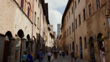 Sunny-day-in-historic-Tuscany-town-San-Gimignano-with-tourists-strolling