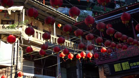 Jiufen-Old-Street's-bustling-square,-featuring-the-Ghost-Lore-Museum-and-red-lanterns-hanging-above-the-plaza,-a-popular-tourist-spot-nestled-in-Taiwan's-mountain-town