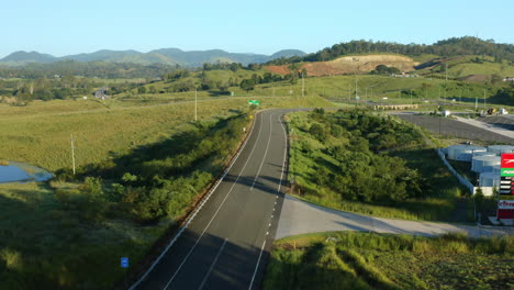 Aerial-4K-Drone-Over-Scenic-Countryside-Highway-With-Bike-Cyclist-On-Road,-Australia