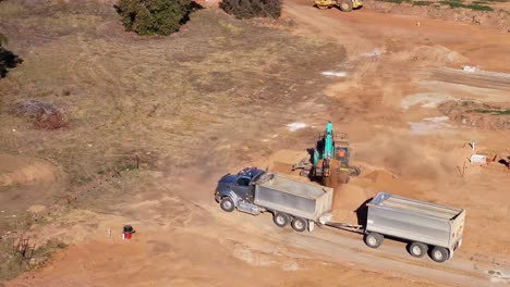 Excavator-from-a-dirt-pile-loading-a-truck-with-dirt