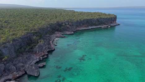 Aerial-drone-flight-over-tropical-waters-along-the-rocky-cliffs-of-Jaragua-National-Park,-Pedernales-in-the-Dominican-Republic