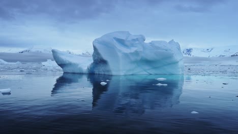 Aerial-drone-shot-of-Antarctica-Icebergs,-Big-Beautiful-Massive-Icebergs-Floating-in-the-Ocean-on-the-Antarctic-Peninsula,-Amazing-Shapes-and-Ice-Formation-Reflection-Reflecting-in-Calm-Still-Water