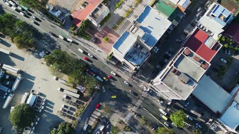 Vista-Aérea-De-Arriba-Hacia-Abajo-De-Una-Intersección-De-La-Ciudad-Con-Mucho-Tráfico-Y-Camiones-Estacionados-En-Metro-Manila,-Filipinas