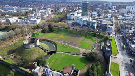 Overhead-shot-of-old-Cardiff-Castle-surrounded-by-modern-buildings-of-the-city,-Wales