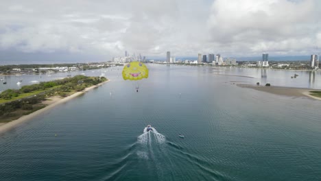 Popular-holiday-tourist-activities-on-a-busy-waterway-with-an-urban-city-skyline-in-the-distance