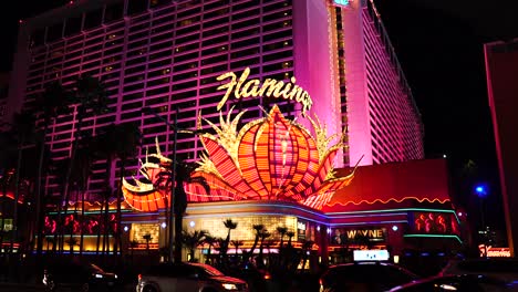 Flamingo-Casino-Hotel-Und-Las-Vegas-Strip-Verkehr-Bei-Nacht,-Leuchtendes-Licht-Auf-Berühmten-Logos-Und-Autos