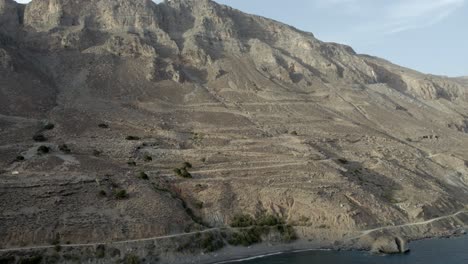 DRONE-SHOT-ZIG-ZAG-ROAD-ON-ROCKY-CLIFF-SIDE-BY-THE-OCEAN-Tris-Ekklisies-Crete-Greece-4k