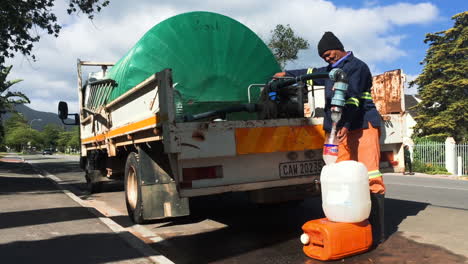 Kommunalarbeiter-Mit-Wasserwagen-Beim-Befüllen-Von-Containern