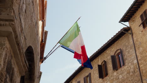 Banderas-Italianas-Y-Europeas-Ondeando-En-Un-Edificio-Rústico