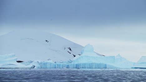 Großer-Eisberg-In-Der-Winterlandschaft-Der-Antarktis,-Erstaunliche-Form-Der-Eisbildung-Aus-Riesigen,-Riesigen-Blauen-Eisbergen-In-Der-Landschaft-Der-Antarktis-Halbinsel-Mit-Meerwasser