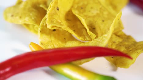 spinning-tortilla-chips-plate-and-hot-peppers,-rotating-dish,-nacho-snack