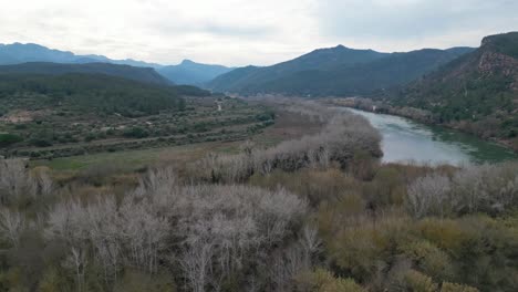 Miravet-town-in-tarragona,-spain-with-mountains-and-a-river,-aerial-view