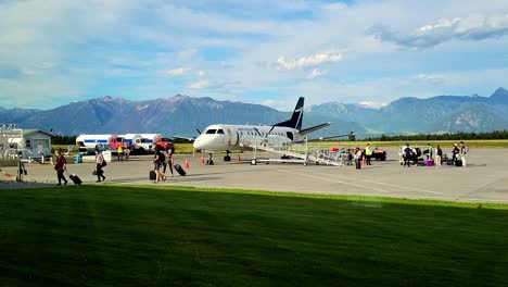 Passagiere-Steigen-Am-Flughafen-Cranbrook-Mit-Ihrem-Gepäck-Aus-Einem-Kleinflugzeug-In-Den-Kootenay-Mountains-Von-BC-Kanada-Aus---Sonniger-Tag,-Blauer-Himmel-Im-Freien