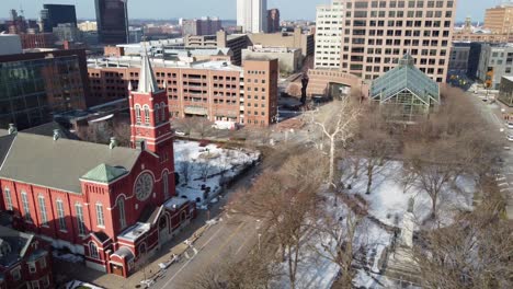 Birds-Flying-in-Washington-Square-Park-Across-from-Church-in-Downtown-Rochester,-New-York