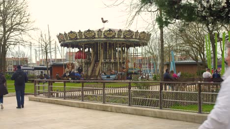 Vintage-carousel-at-fair-in-park-with-people-enjoying-walking-around