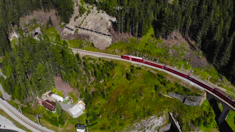 Aerial:-red-train-in-mountainous-landscape